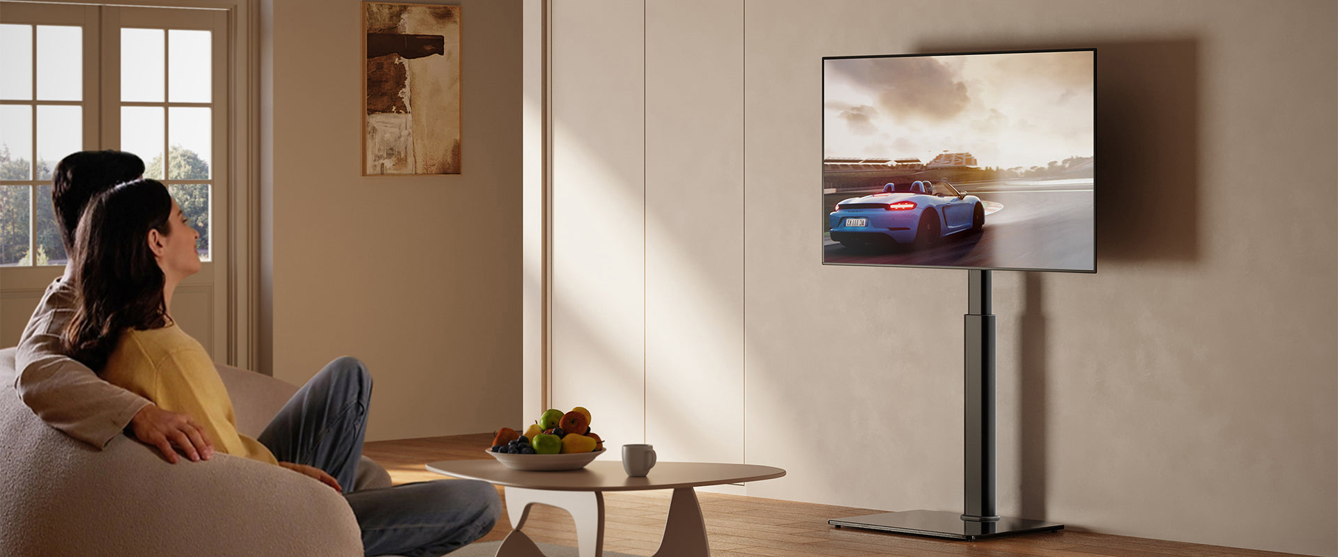 Black floor TV stand with glass base. This TV stand for bedrooms and living rooms. It can be adjusted in height for a comfortable viewing experience.
